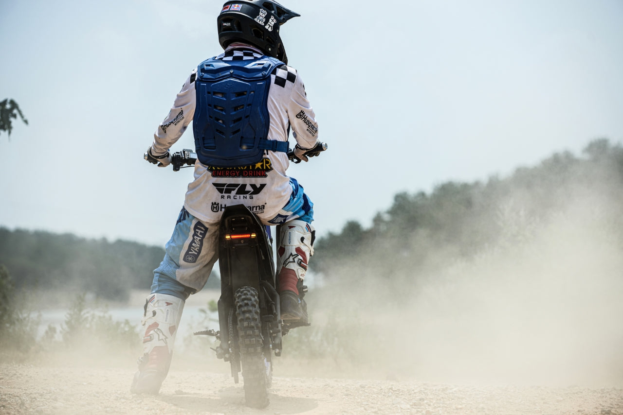Evoltrix ROGUE MX-01 Off-Road Electric Dirt Bike, Rider from Behind on Dirt Trail Kicking Up Dust