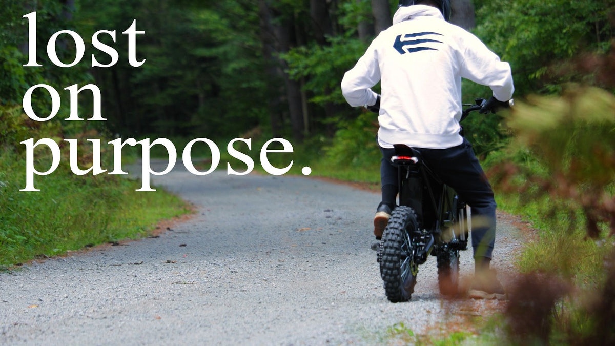 Load video: Powerful 5500W Evoltrix MAX-60 black electric dirt bike ridden by a helmeted rider on a trail.
